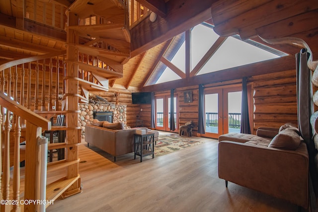 living room with beamed ceiling, french doors, a fireplace, wood finished floors, and high vaulted ceiling