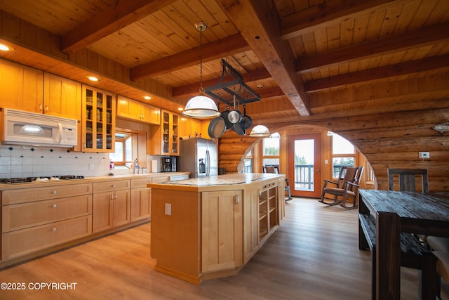 kitchen featuring white appliances, light wood-type flooring, wooden ceiling, and a center island