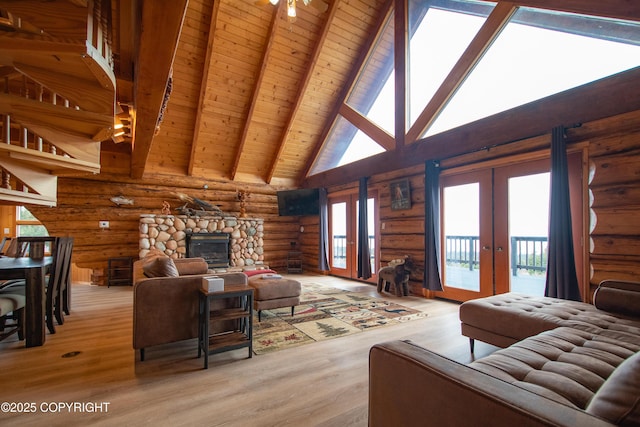 living room with beam ceiling, a healthy amount of sunlight, french doors, and light wood-style flooring