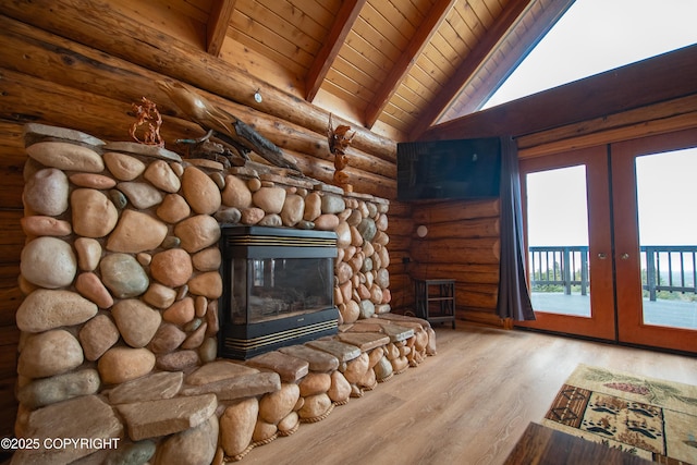 unfurnished living room with lofted ceiling with beams, wood finished floors, french doors, a fireplace, and wood ceiling