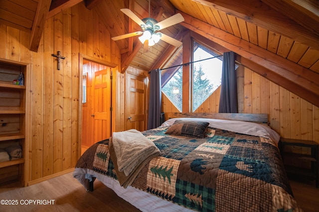 bedroom featuring wood finished floors, baseboards, vaulted ceiling with beams, wood walls, and wooden ceiling