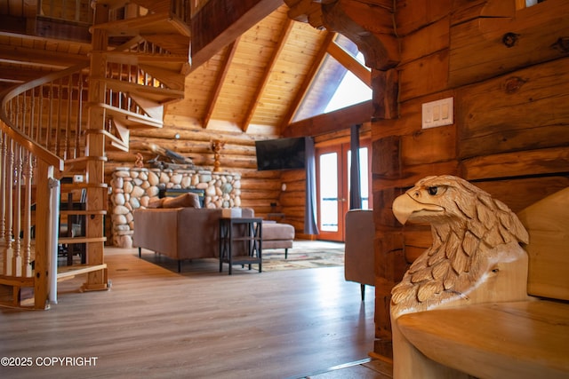 living area with beam ceiling, high vaulted ceiling, wood finished floors, stairway, and wooden ceiling