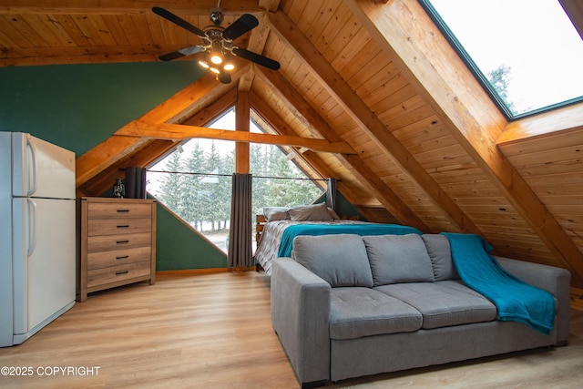 unfurnished bedroom featuring wood ceiling, vaulted ceiling with skylight, light wood-type flooring, and freestanding refrigerator