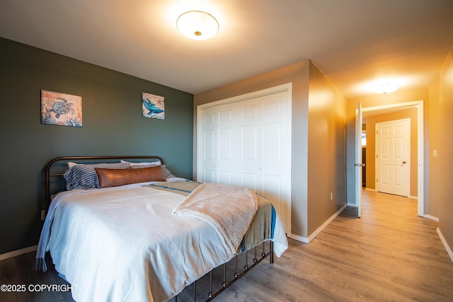 bedroom featuring a closet, baseboards, and wood finished floors