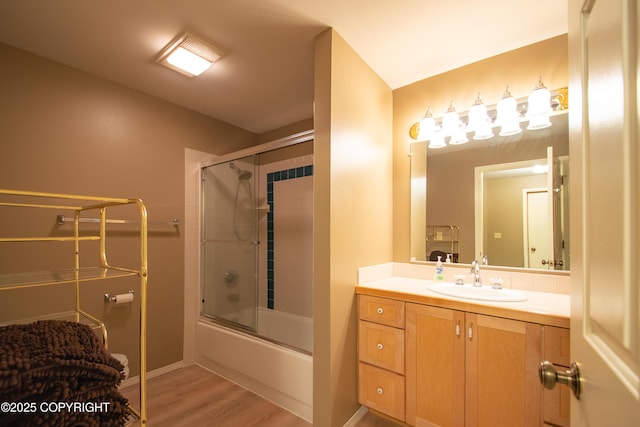 full bathroom with shower / bath combination with glass door, wood finished floors, and vanity