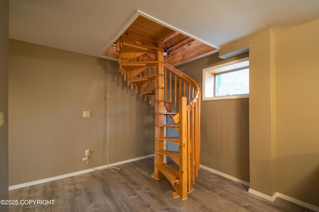 stairs with wood finished floors and baseboards