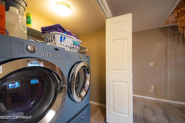 washroom with baseboards, independent washer and dryer, wood finished floors, and laundry area