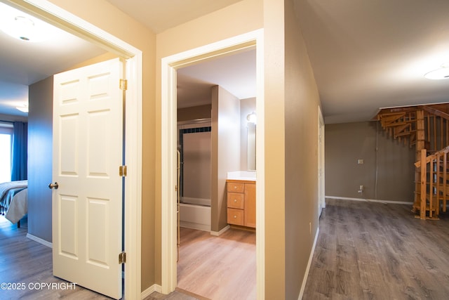 hall featuring baseboards and light wood finished floors