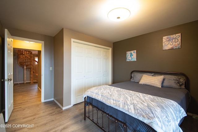 bedroom with a closet, baseboards, and wood finished floors