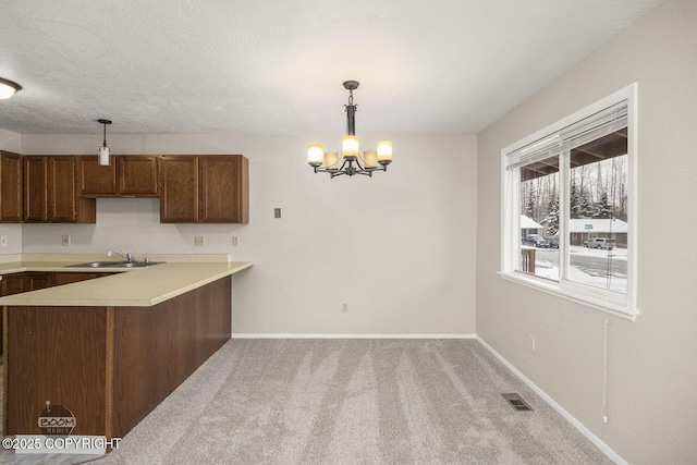 kitchen with hanging light fixtures, an inviting chandelier, visible vents, and carpet floors