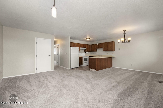 kitchen with white appliances, light countertops, light carpet, open floor plan, and a chandelier