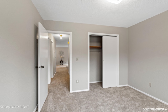 unfurnished bedroom with carpet floors, baseboards, and a closet