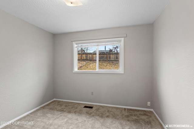 spare room featuring baseboards, carpet, and visible vents