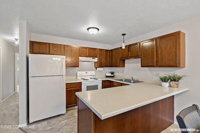 kitchen with a sink, white appliances, light countertops, a peninsula, and under cabinet range hood