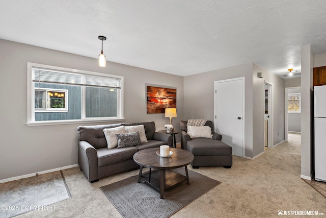 living room featuring baseboards, plenty of natural light, and light carpet