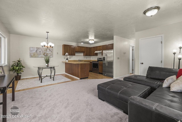 living room with baseboards, light colored carpet, an inviting chandelier, and a textured ceiling