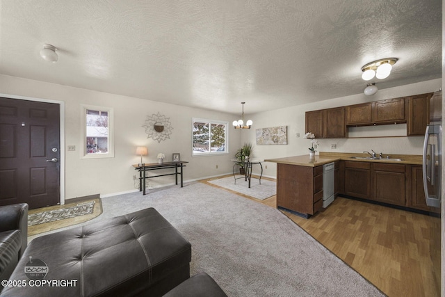 living room with baseboards, light wood-style flooring, a textured ceiling, and an inviting chandelier