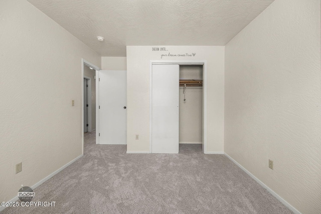 unfurnished bedroom with a textured ceiling and a textured wall