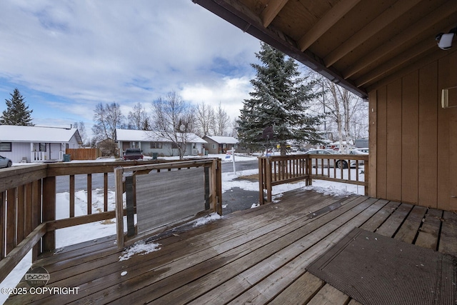 snow covered deck featuring a residential view