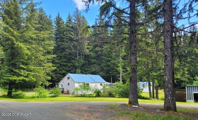 38 Helms Loop Spur, Haines, AK 99827 - view of property exterior with a wooded view, a yard, and dirt driveway