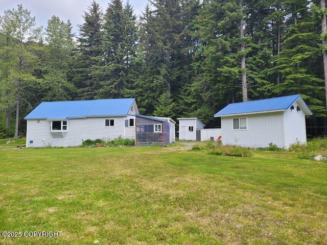 38 Helms Loop Spur, Haines, AK 99827 - view of grassy yard with an outdoor structure and a wooded view