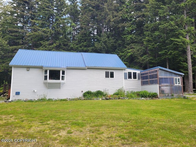 38 Helms Loop Spur, Haines, AK 99827 - view of property exterior featuring metal roof, a lawn, and a sunroom