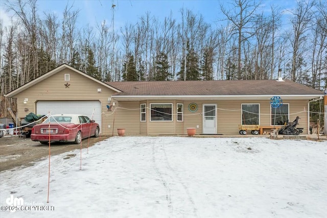 ranch-style house with an attached garage and a shingled roof