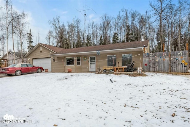 view of front of house with an attached garage, fence, and a chimney