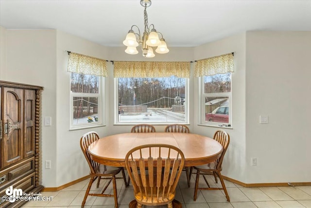 dining area featuring a chandelier, light tile patterned floors, a healthy amount of sunlight, and baseboards