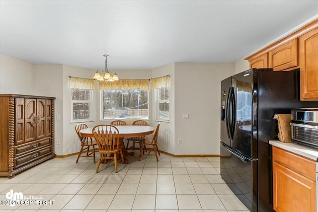 dining area with light tile patterned floors, baseboards, and a chandelier