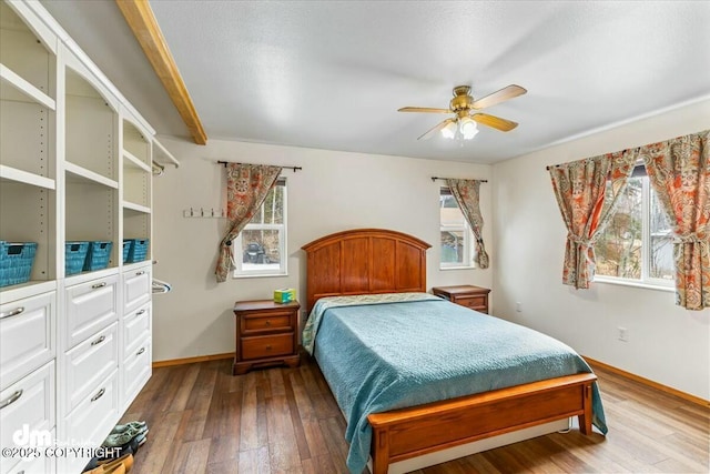 bedroom with multiple windows, ceiling fan, baseboards, and hardwood / wood-style flooring