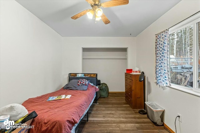 bedroom featuring wood finished floors, baseboards, and ceiling fan