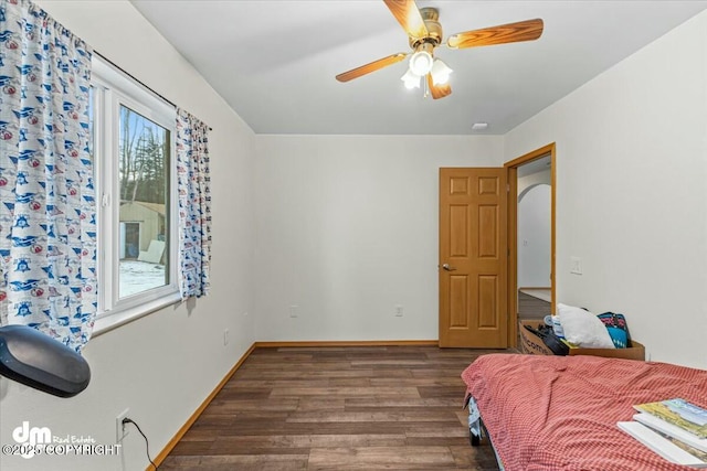 bedroom featuring a ceiling fan, baseboards, and wood finished floors