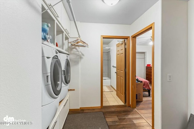 laundry room featuring laundry area, wood finished floors, baseboards, and washer and clothes dryer