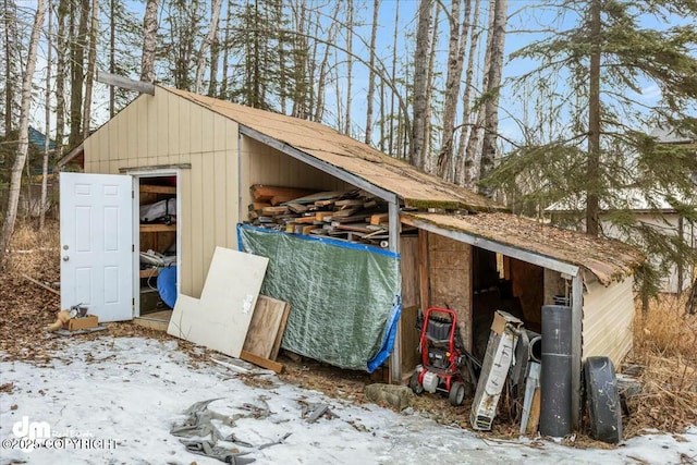 snow covered structure with an outbuilding and a pole building