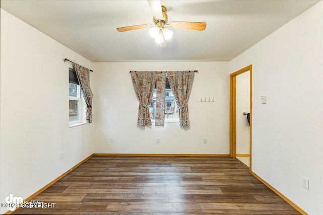 empty room featuring baseboards, wood finished floors, and ceiling fan