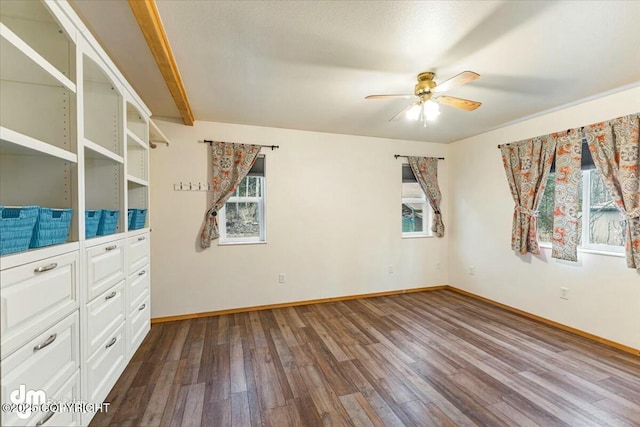 empty room with baseboards, ceiling fan, and dark wood finished floors