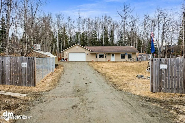 view of front of house with an attached garage, aphalt driveway, and fence