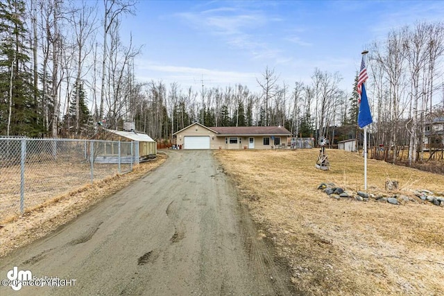 view of front of house with fence, aphalt driveway, and a garage
