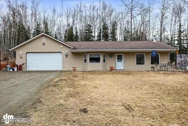 single story home featuring roof with shingles, dirt driveway, and a garage