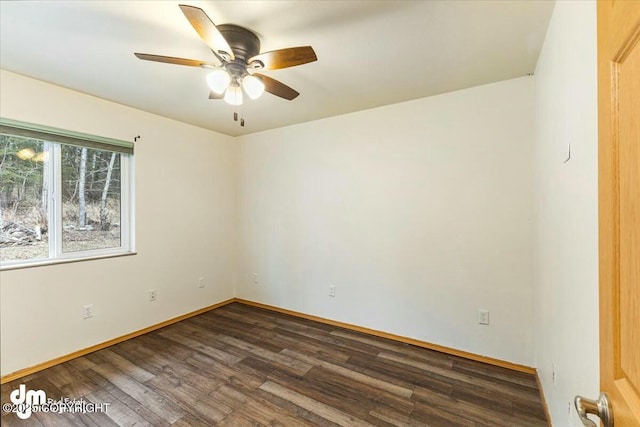 empty room with baseboards, a ceiling fan, and dark wood-type flooring