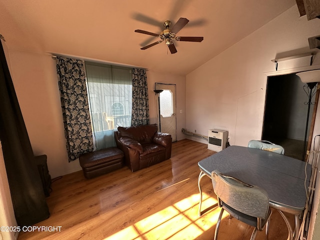 living room featuring vaulted ceiling, light wood-style flooring, heating unit, and a ceiling fan