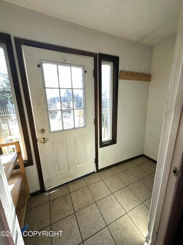 doorway to outside featuring tile patterned floors and a healthy amount of sunlight