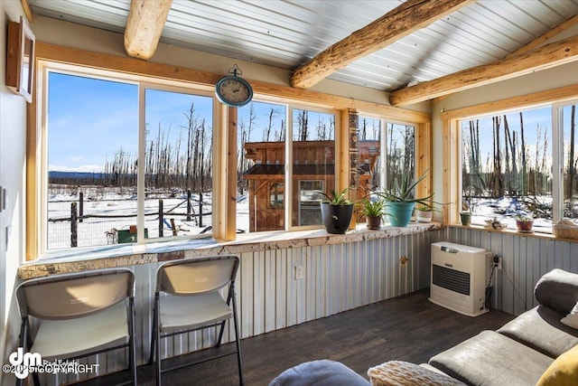 sunroom featuring heating unit, wood finished floors, and beamed ceiling