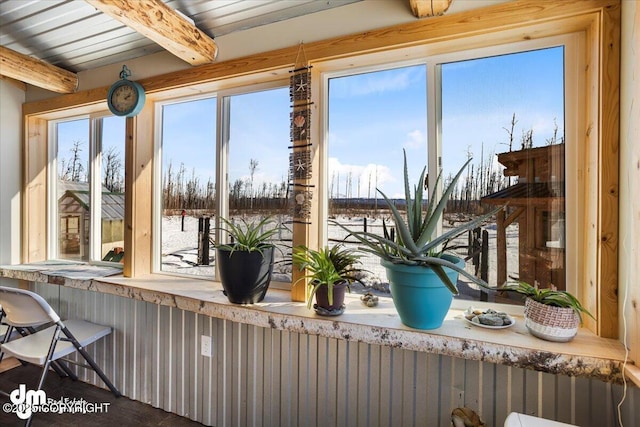 sunroom / solarium with beam ceiling and a healthy amount of sunlight