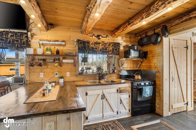 kitchen featuring wooden ceiling, a sink, wooden walls, wooden counters, and gas stove