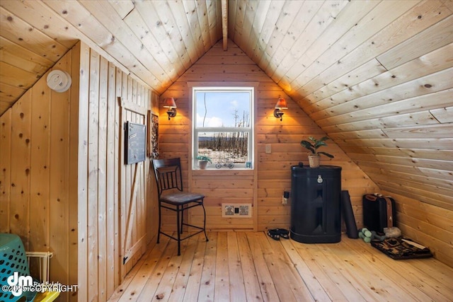 additional living space featuring lofted ceiling, wooden walls, wooden ceiling, and wood-type flooring