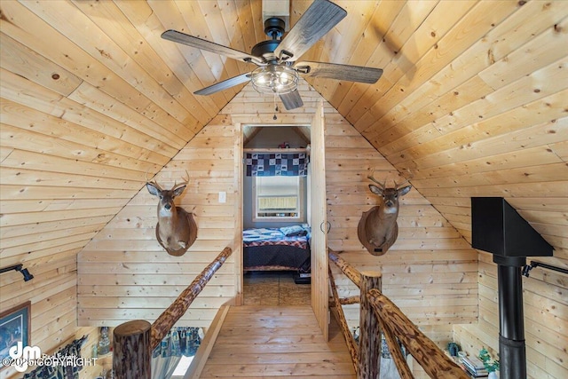 hallway with lofted ceiling, wooden ceiling, wood walls, and wood-type flooring