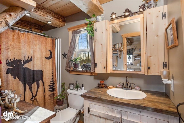 full bathroom with toilet, wood ceiling, curtained shower, vanity, and beamed ceiling
