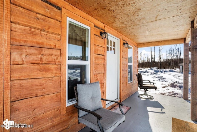 snow covered patio featuring a porch